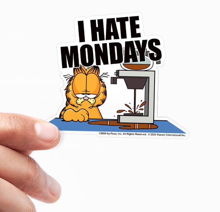 Vinyl sticker held by fingers; 'I HATE MONDAYS' text with orange cat and printer coffee