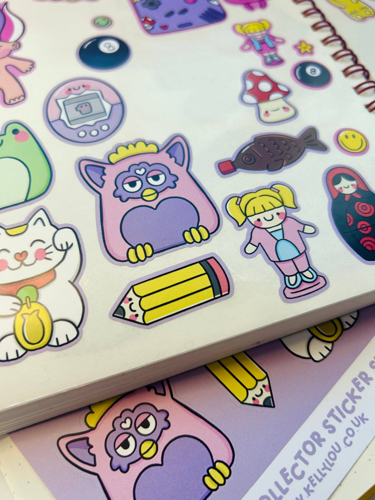 Vinyl sticker sheet close-up with cat, owl, girl, rocket, pencil, and mushroom stickers.