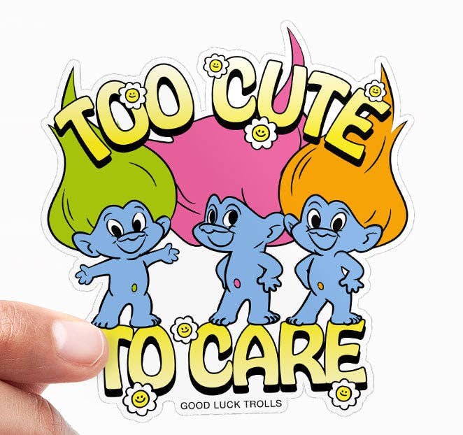 Vinyl sticker held by hand, showing three trolls and 'Too Cute To Care' text.