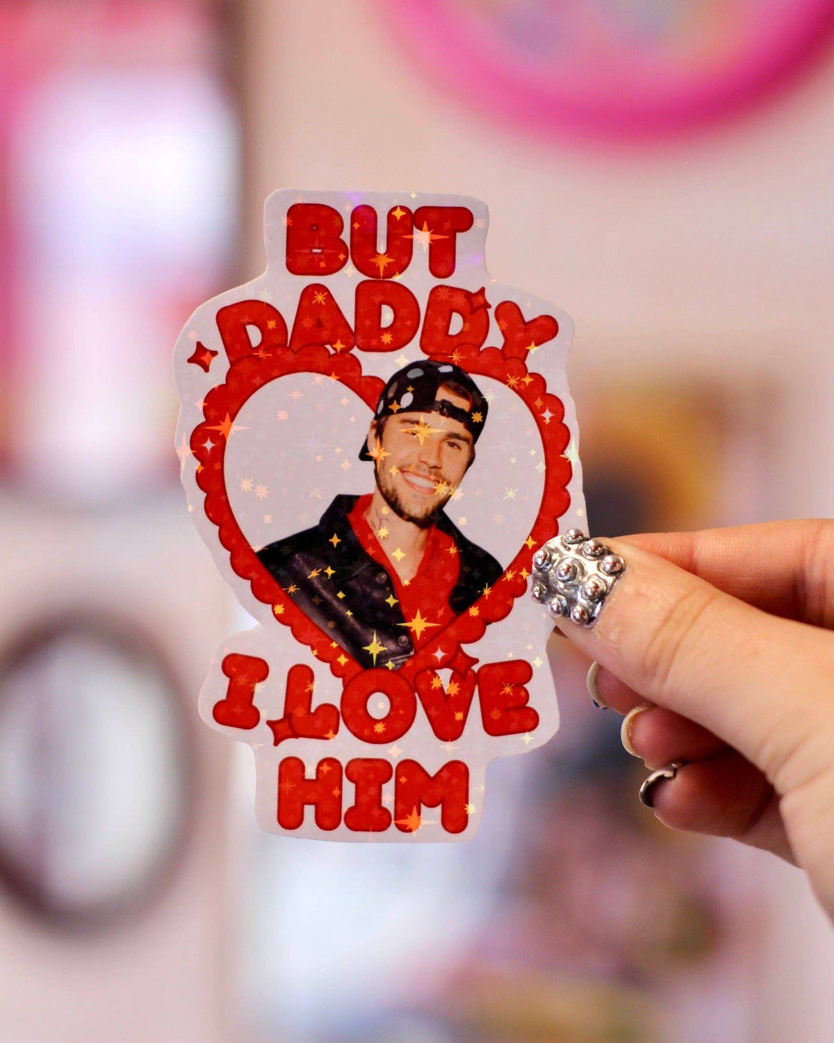 Heart-shaped sticker showing Justin Bieber portrait with red “But Daddy I love him” text