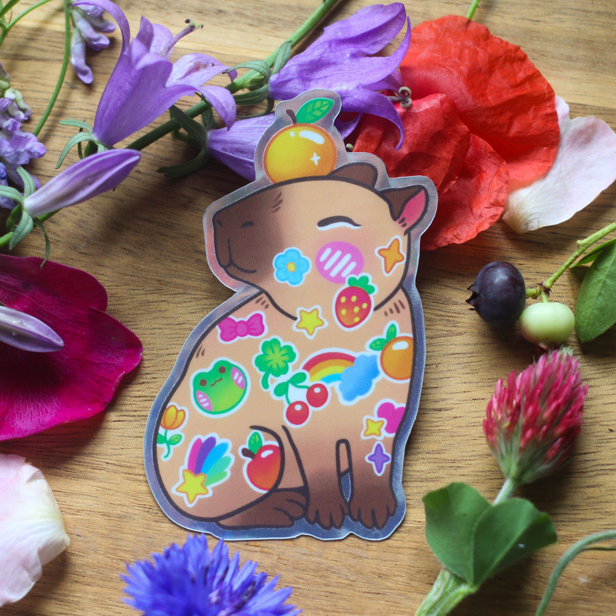 Vinyl sticker of cartoon brown animal with colorful fruit, stars, and flowers