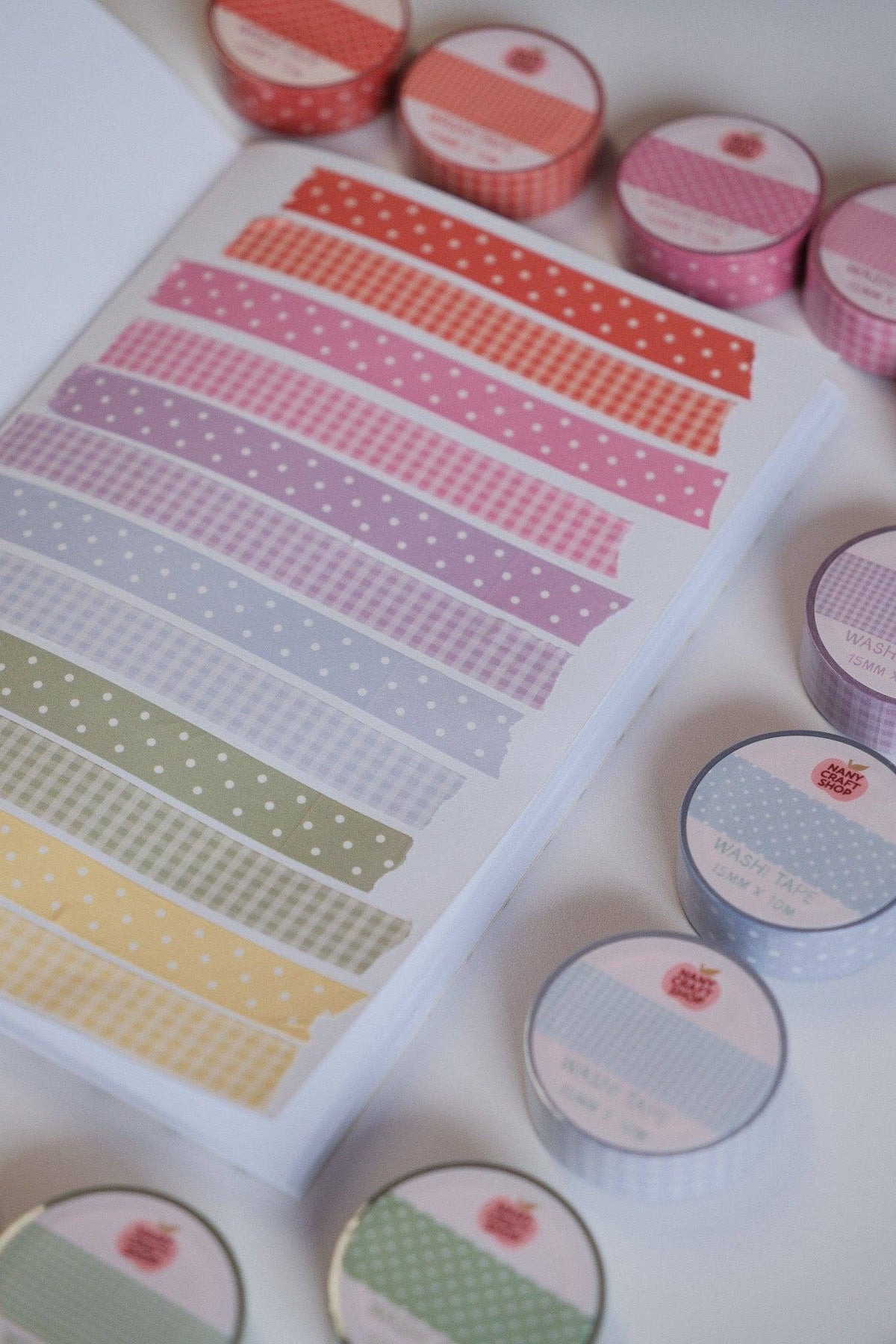 Blue gingham washi tape strips on sheet, with several rolls in blue and other colors.
