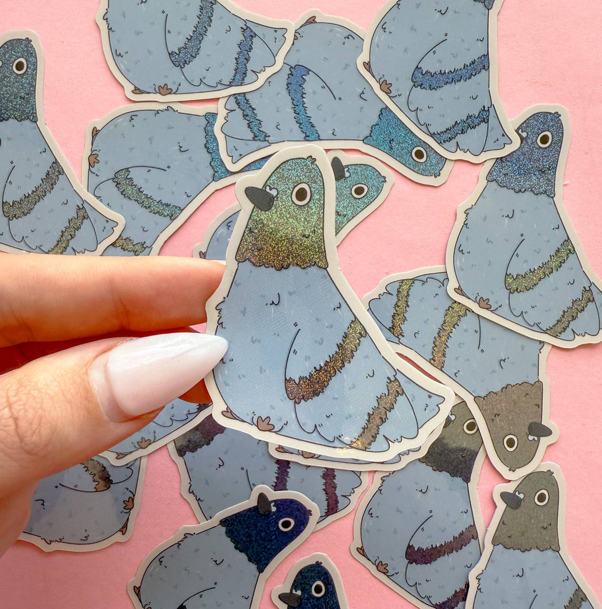 Pigeon vinyl sticker held by hand, blue-gray illustrated bird with gold eye