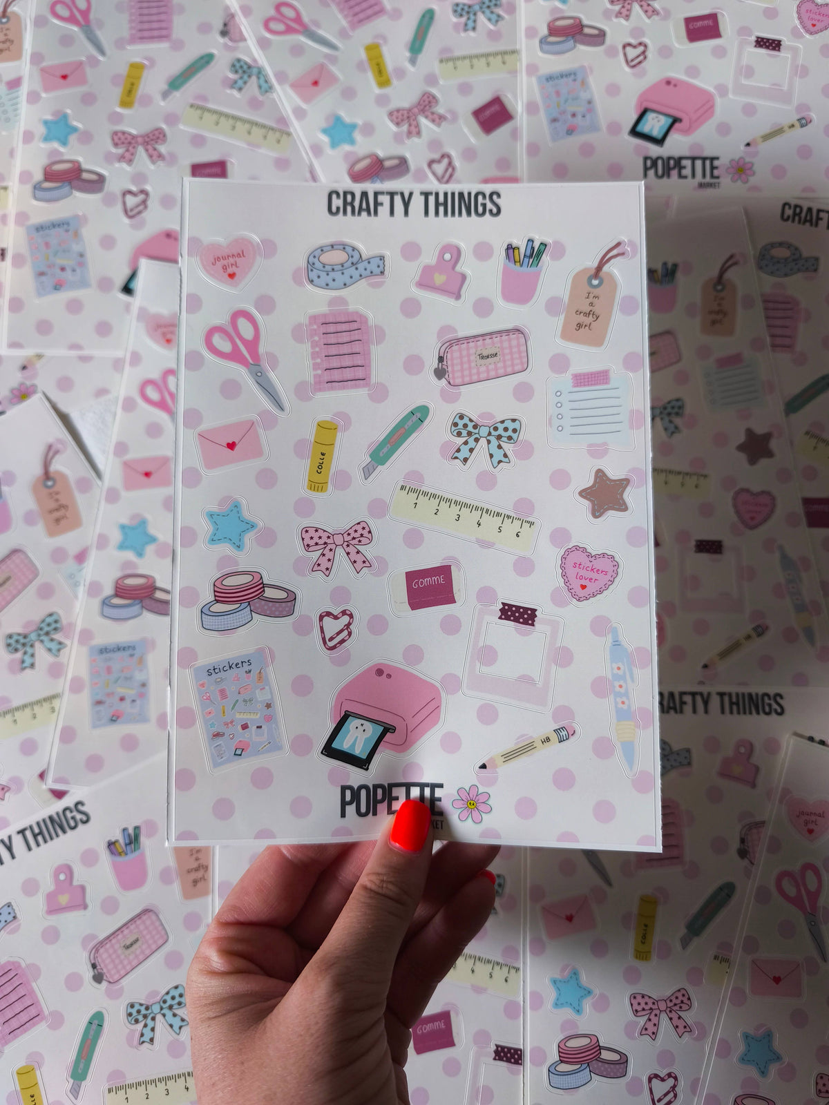 A5 sticker sheet close-up held in hand, pastel tools, bows, and labels