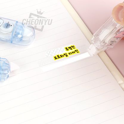 Correction tape and glue tape applying over lined paper, clear tape dispenser visible.