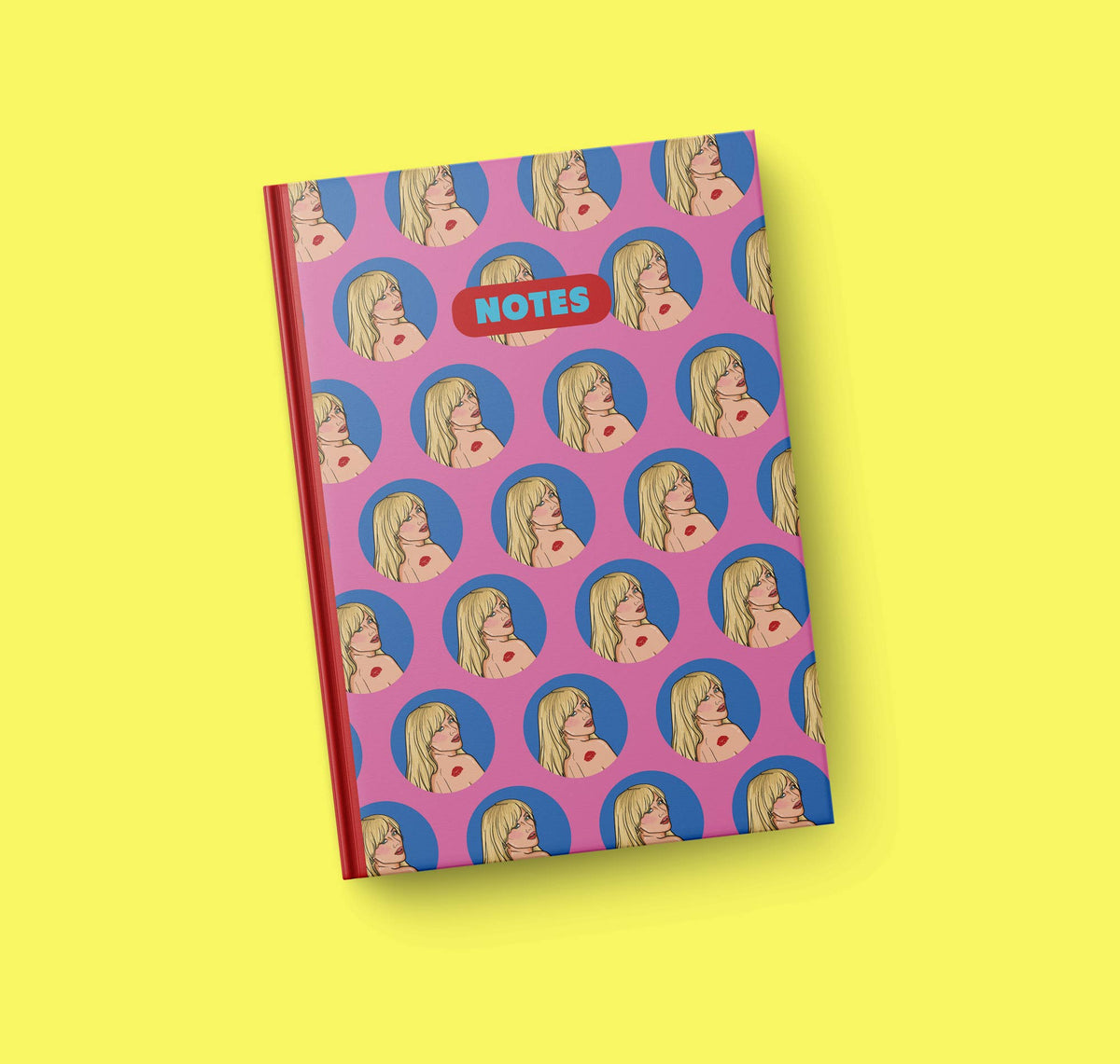 A5 notebook with purple patterned cover featuring circular face icons and a red spine edge.