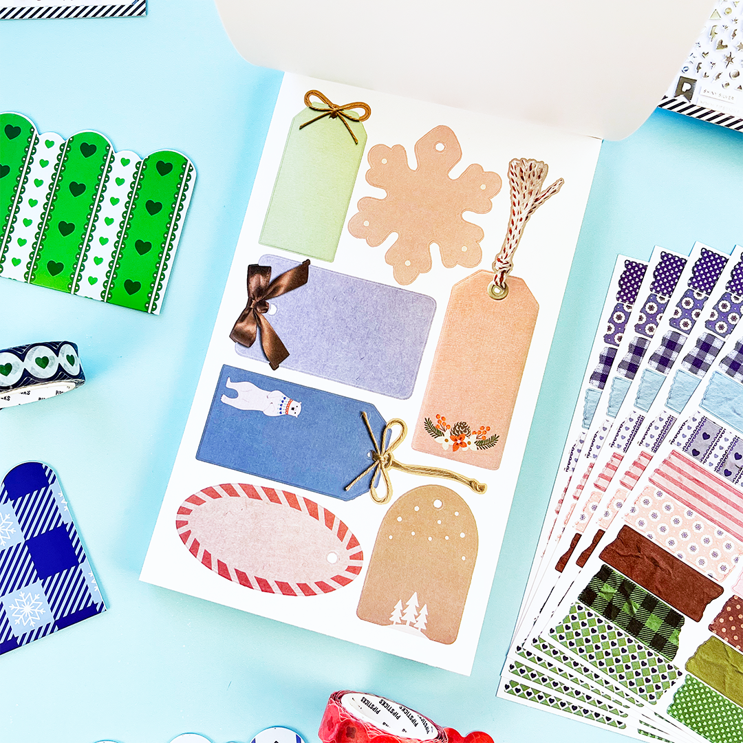 Sticker sheet with tags and shapes in orange, blue, and gold, plus bow and twig details