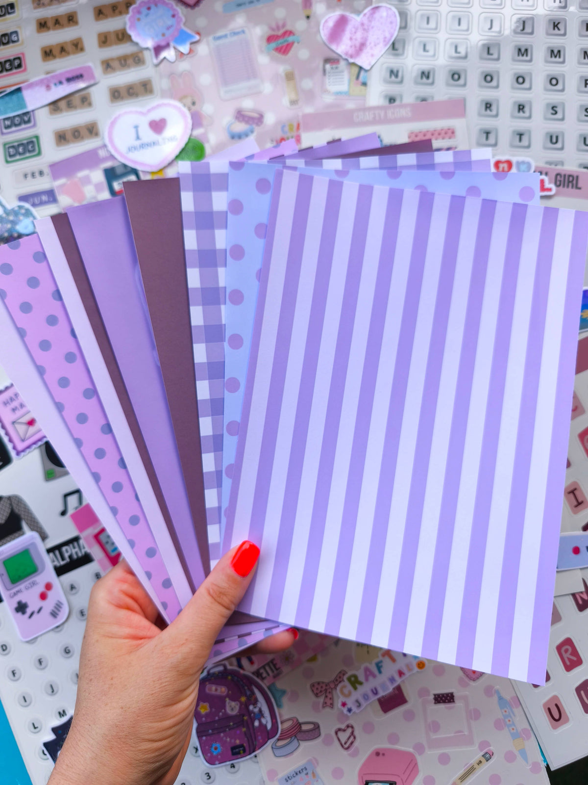 Junk papers charm papers, purple and white striped sheet held in hand with other patterned papers