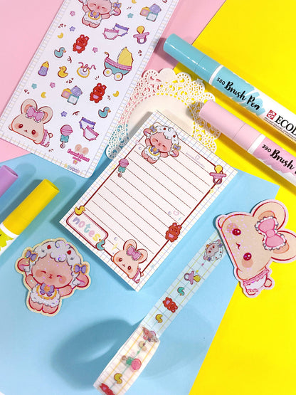 Baby-themed notepad with ruled pages and ribbon frame, showing sheep and toys
