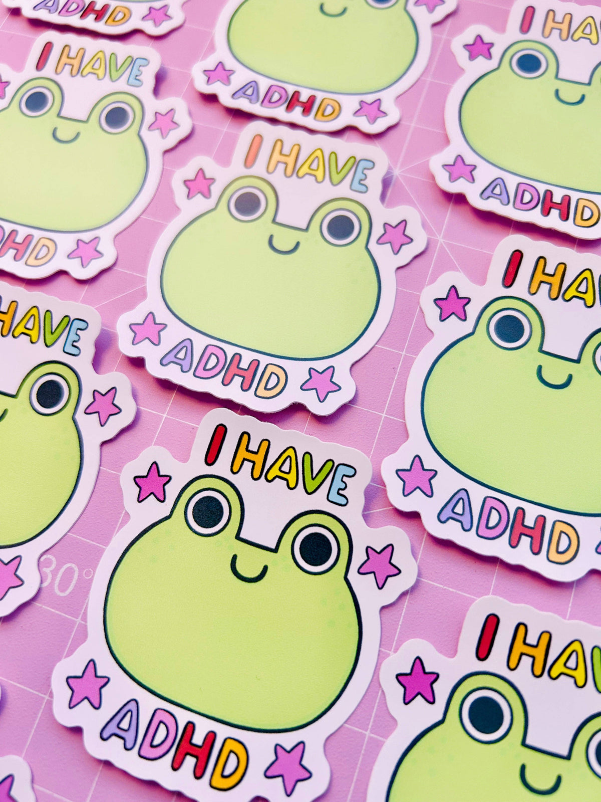Set of vinyl stickers with green frog faces, “I HAVE ADHD” text, and star icons