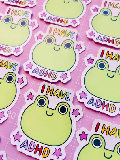 Set of vinyl stickers with green frog faces, “I HAVE ADHD” text, and star icons