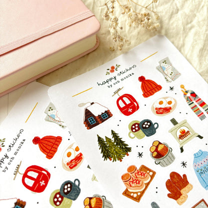 Angle view of winter sticker sheet with hat, lantern, scarf, food, and pine branch icons