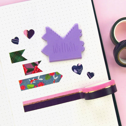 Purple house-shaped washi cutter on dotted paper with decorative hearts and tape strips