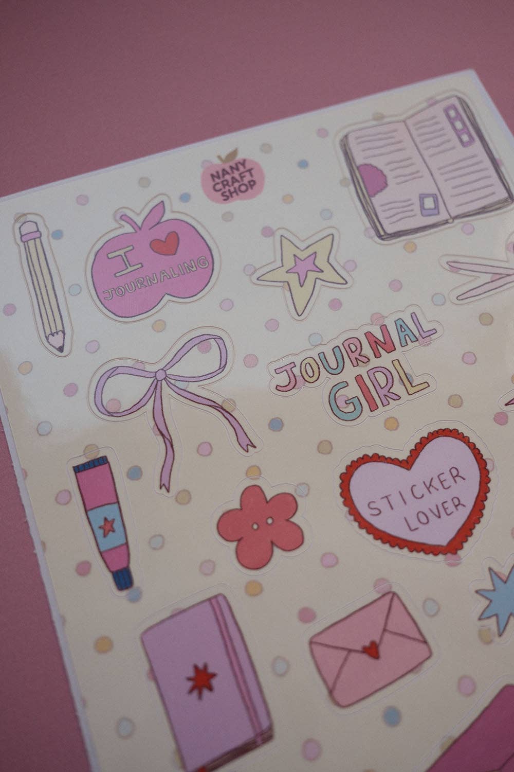 A5 sticker sheet close-up with Journal Girl text, heart sticker, stars, ribbon and pen icons
