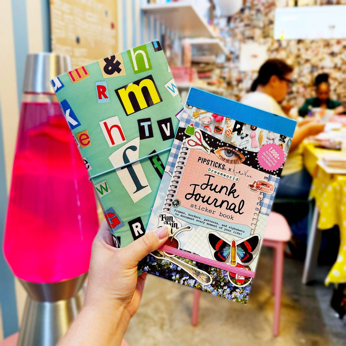 Hand holding junk journal sticker book with colorful cover and “Junk Journal” title