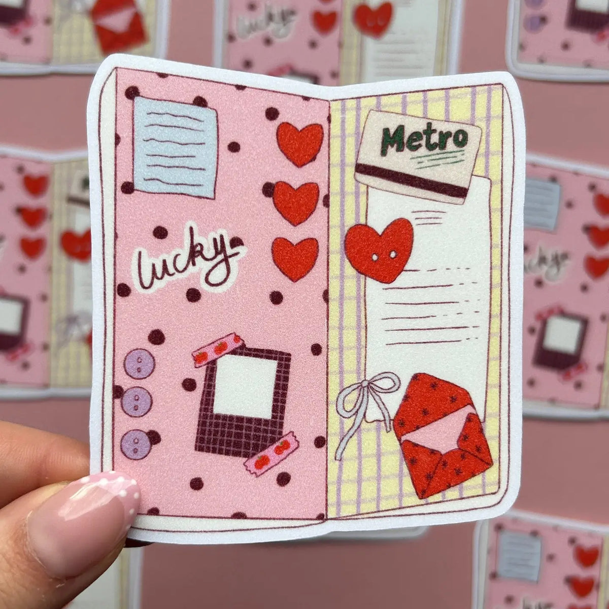 Booklet-shaped sticker with hearts, notes, and a red envelope (Metro)
