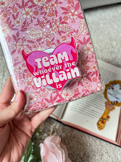 Pink devil heart magnetic grip on floral book cover, 'Team whoever the villain is'