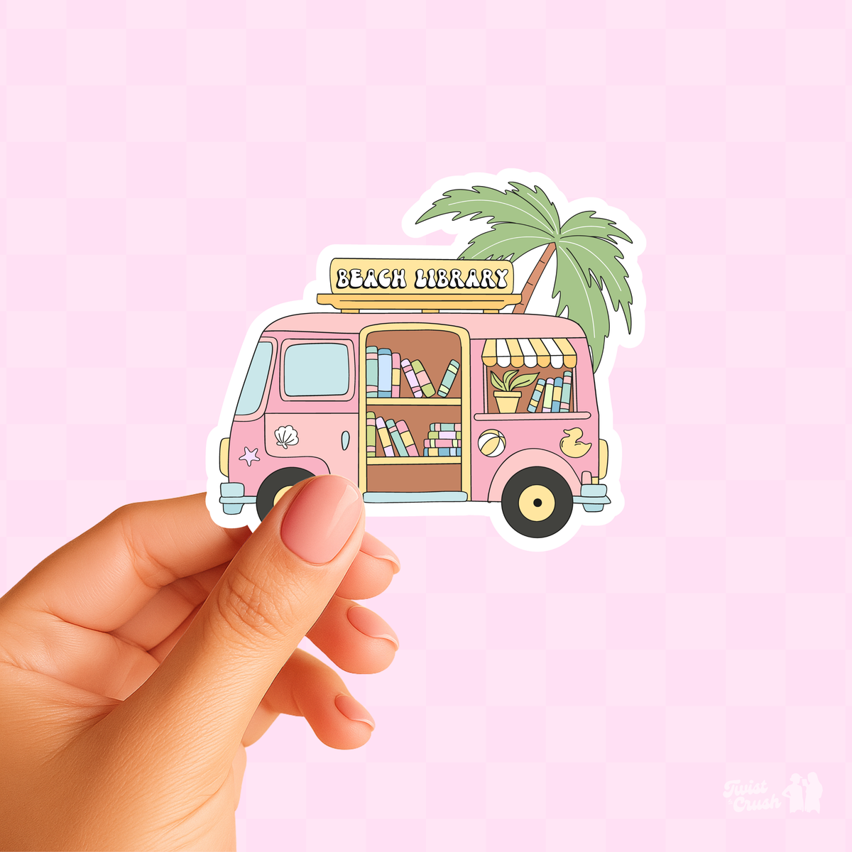 Beach Library sticker: pink book van with palm tree and books, held by hand