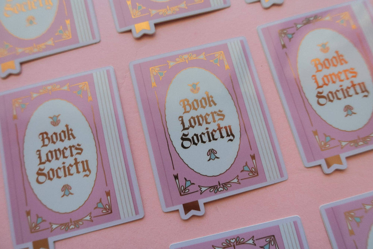 Vinyl sticker cards showing oval “Book Lovers Society” text with purple and gold details