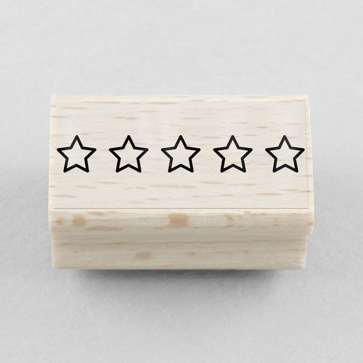 Wooden stamp block with five black star outlines, rating mark stamp