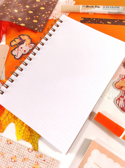 Open spiral notebook with blank pages and orange cover