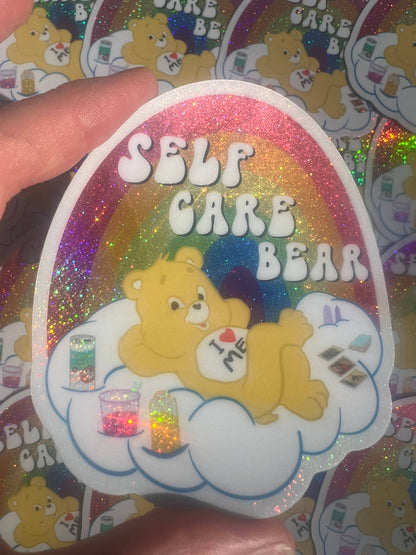 Close-up 3-inch Self Care Bear glitter sticker with bear on cloud and rainbow glitter edge