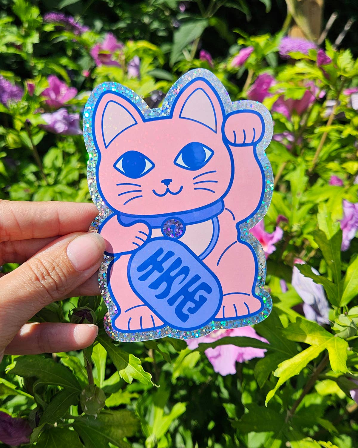 Glitter vinyl lucky cat sticker held in hand, pink cat with blue fortune coin
