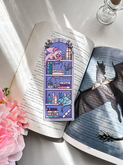 Fantasy bookmark showing a purple catlike creature among stacked books
