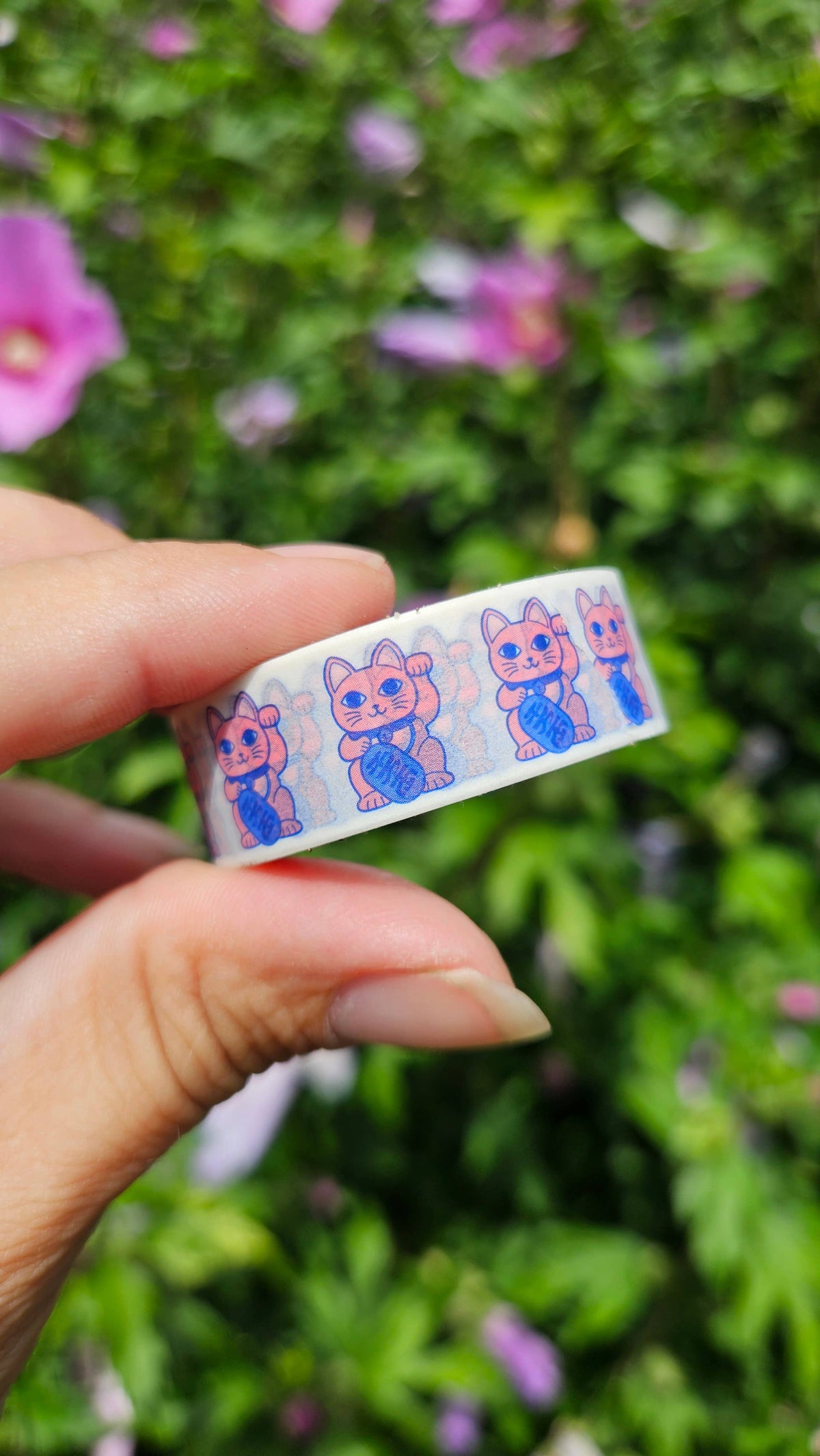 Maneki neko washi tape strip held in hands, showing small cat illustrations