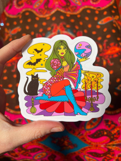 Colorful witch and cat sticker with white border, close-up in hand