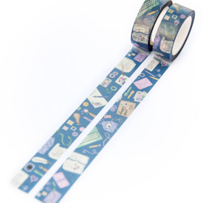 Blue washi tape dispenser roll with stationery-themed pattern and matching inner tape.