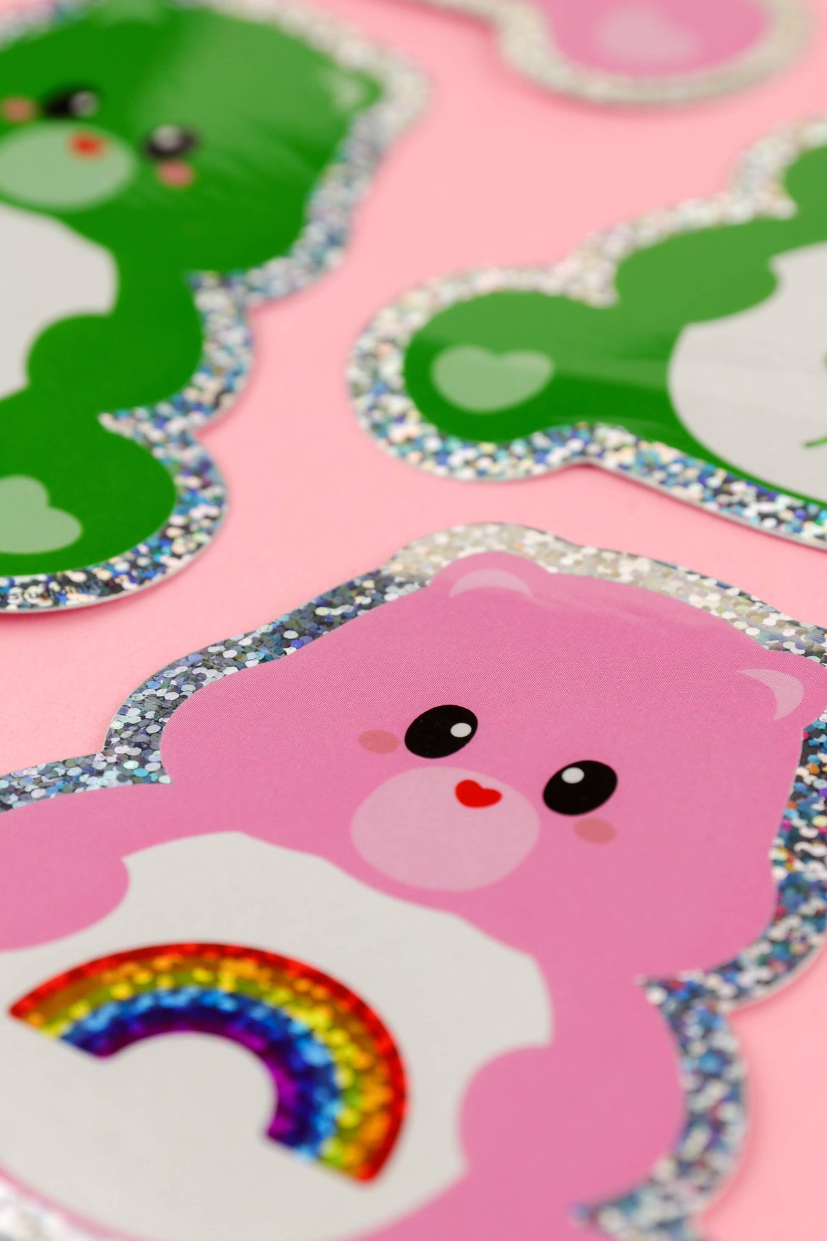 Close-up glitter border sticker of pink bear face with rainbow graphic