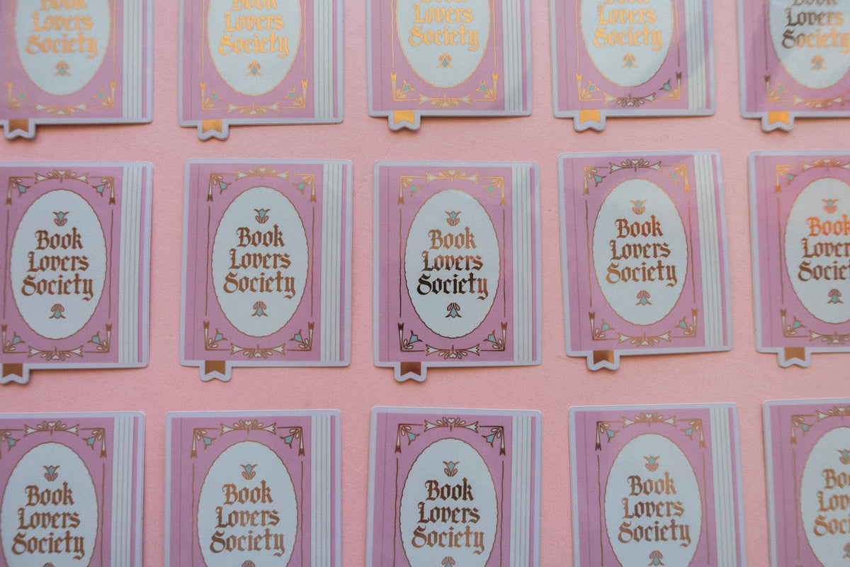 Vinyl sticker cards displayed in multiple rows, each with oval “Book Lovers Society” logo