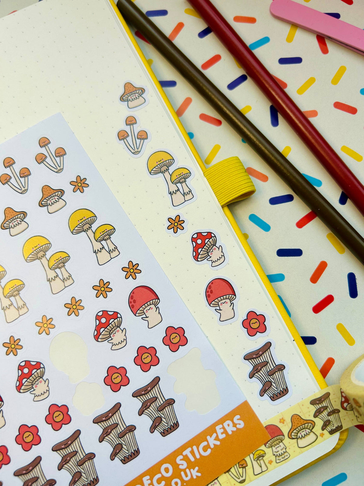 Deco sticker sheet corner with tiny mushroom icons, red flowers, and brown striped mushrooms