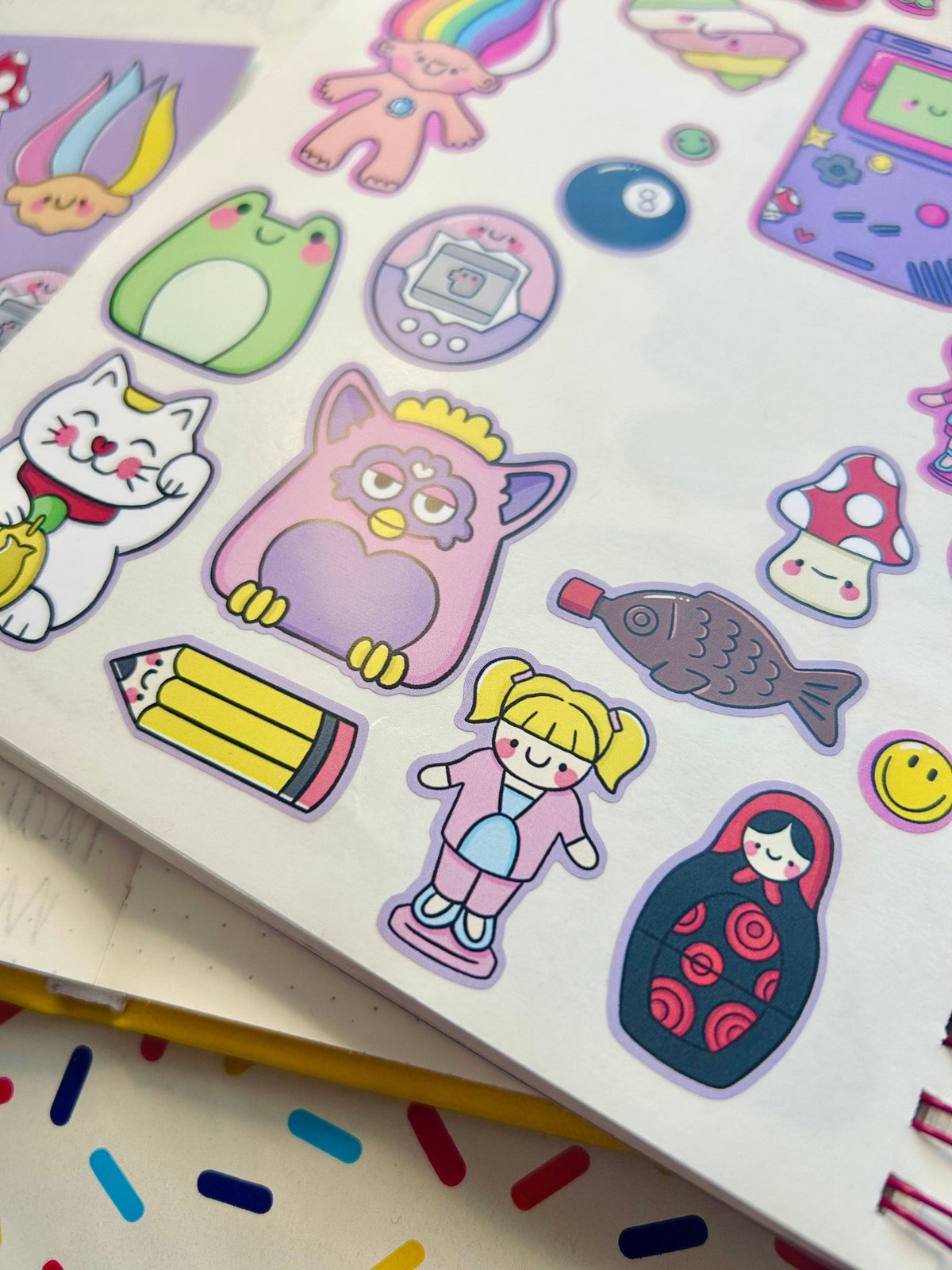 Vinyl sticker sheet with colorful stickers: green egg, cat, pencil, mushrooms, fish, girl.
