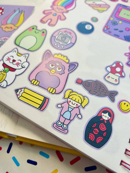 Vinyl sticker sheet with colorful stickers: green egg, cat, pencil, mushrooms, fish, girl.