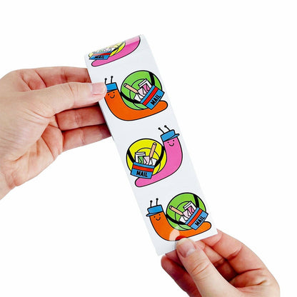Sticker roll strip held by hands with colorful snail-mail character designs, pink orange