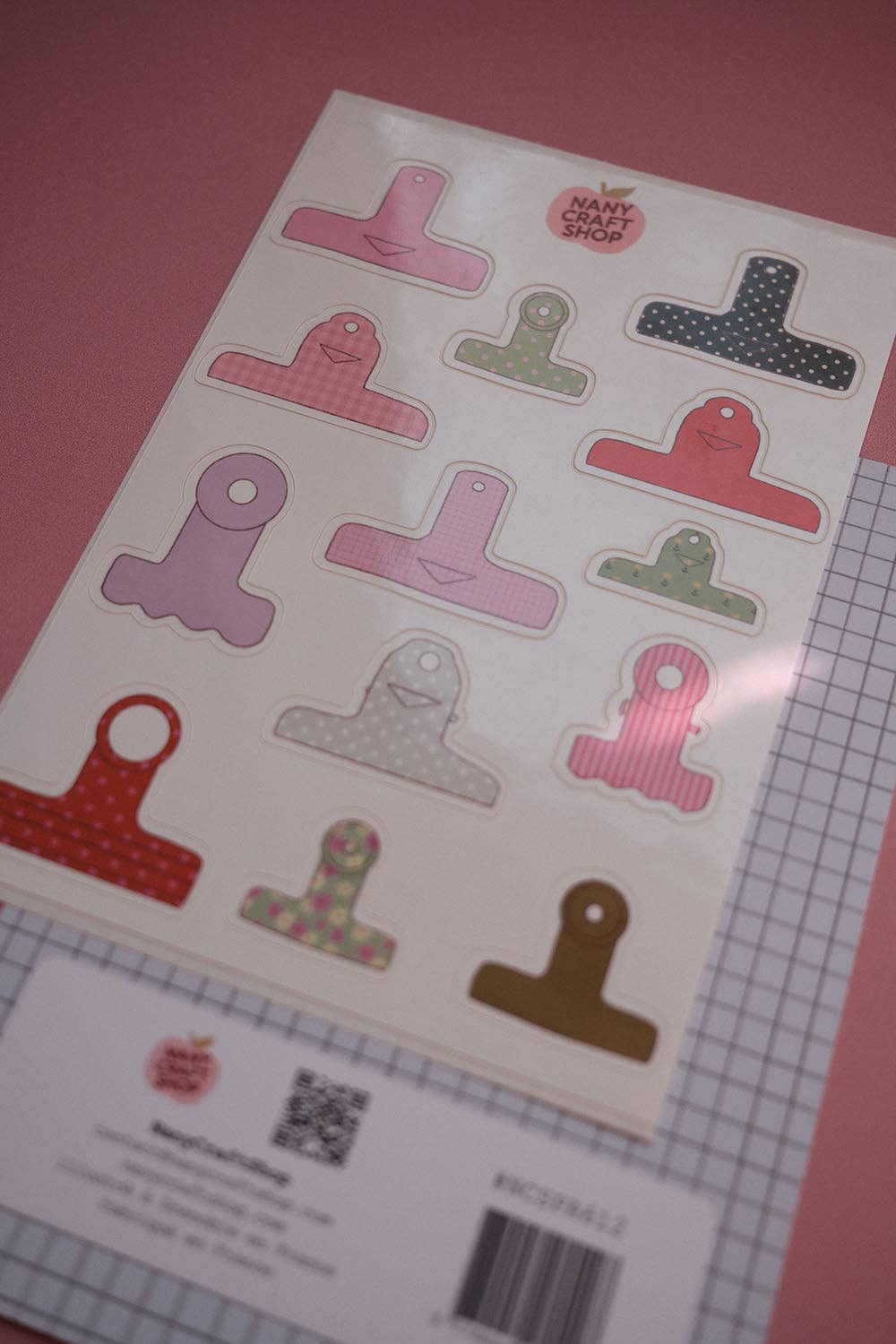 Board clamps sticker sheet with colorful clamp pieces and product label at bottom