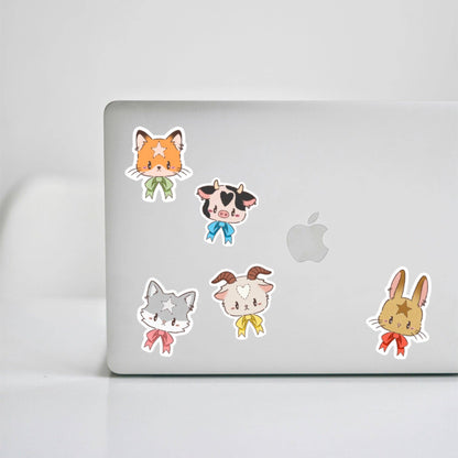 Mystery animal stickers on laptop: orange cat, cow, gray cat, and rabbit
