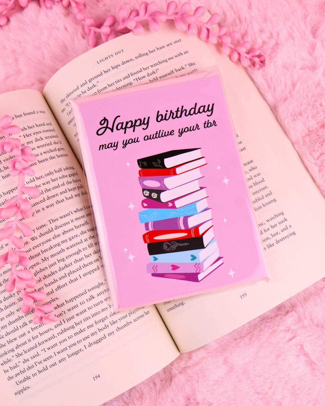 Pink birthday greeting card with stacked books graphic and 'Happy birthday' text