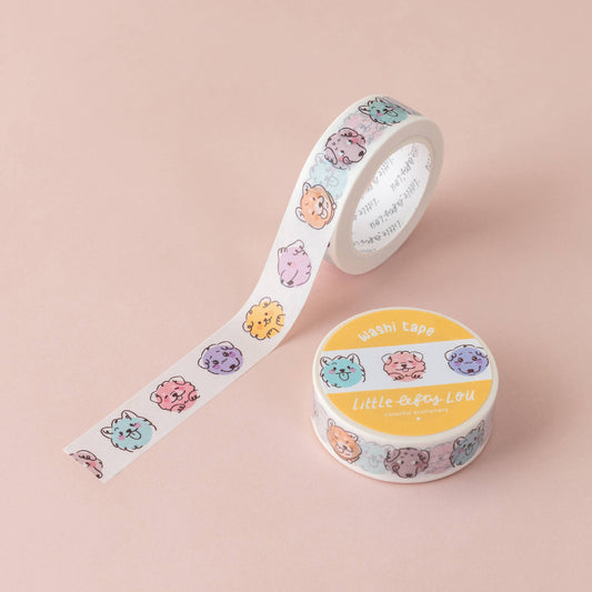 Washi tape roll with colorful dog-face strip beside matching roll