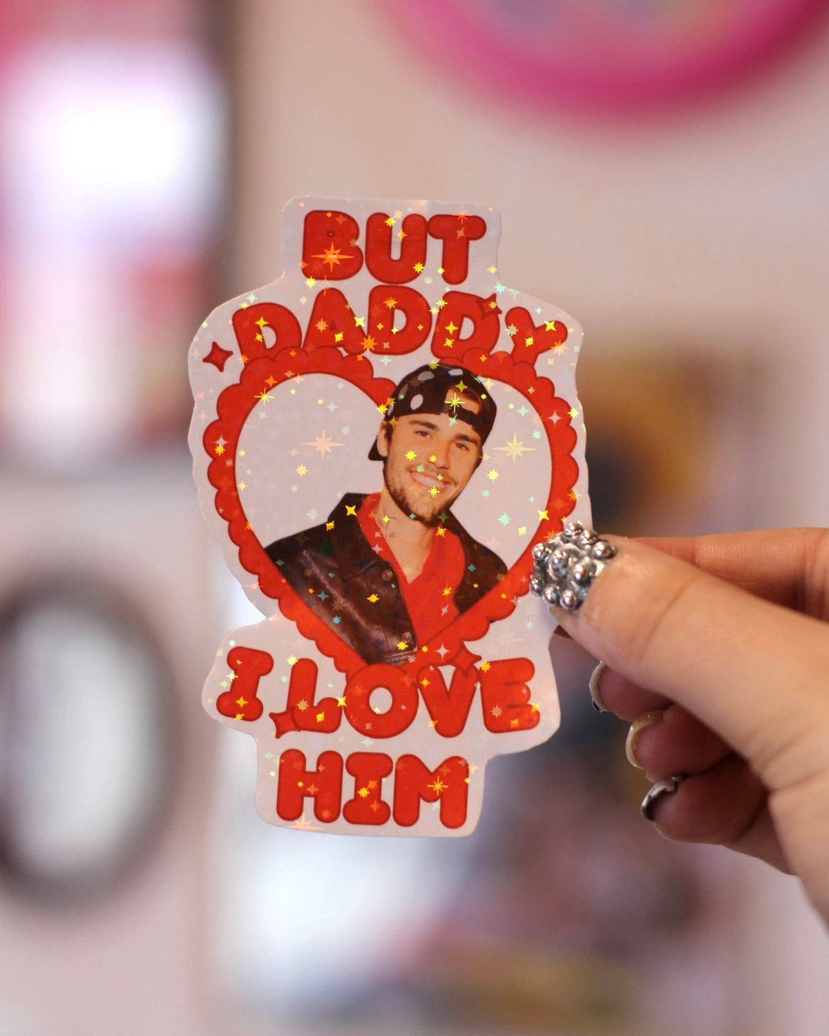 Heart-shaped sticker with Justin Bieber portrait and red text “But Daddy I love him”