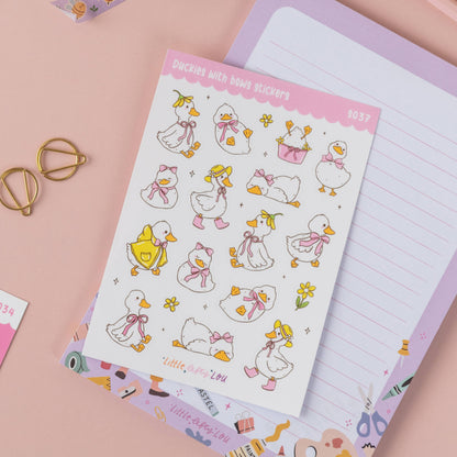 Duck sticker sheet with bows, flowers, and ribbon accents on a page