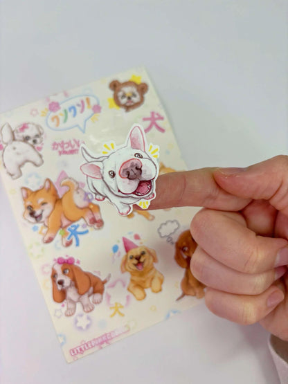 Puppy sticker sheet held by hand, close-up of dog face stickers