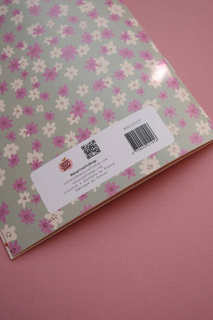 Scrapbook paper sheet with small floral pattern on back and barcode label near bottom