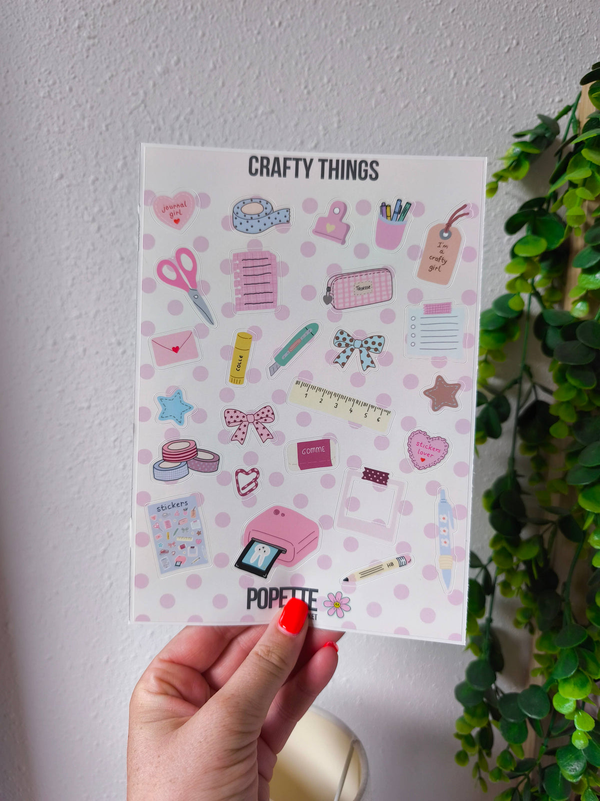 A5 sticker sheet held up, pastel sewing and stationery icons with pink hearts