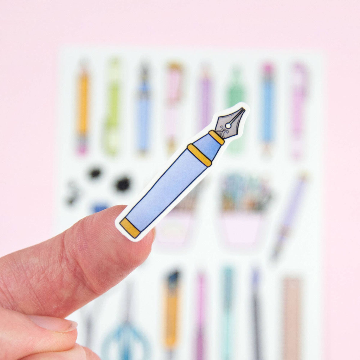 Sticker pen graphic held in hand, blue barrel and yellow nib