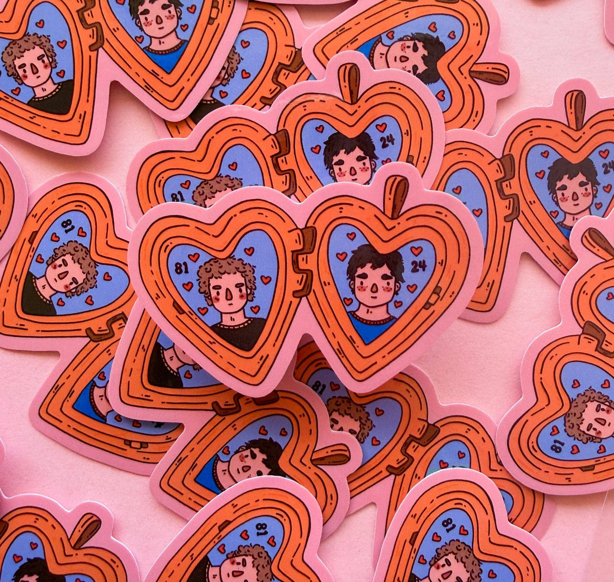 Heated Rivalry vinyl sticker sheet with heart-shaped orange badges featuring cartoon faces