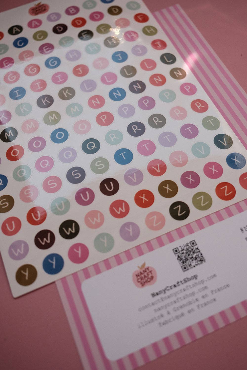 Alphabet letter sticker sheet with multicolor circular letters and product label