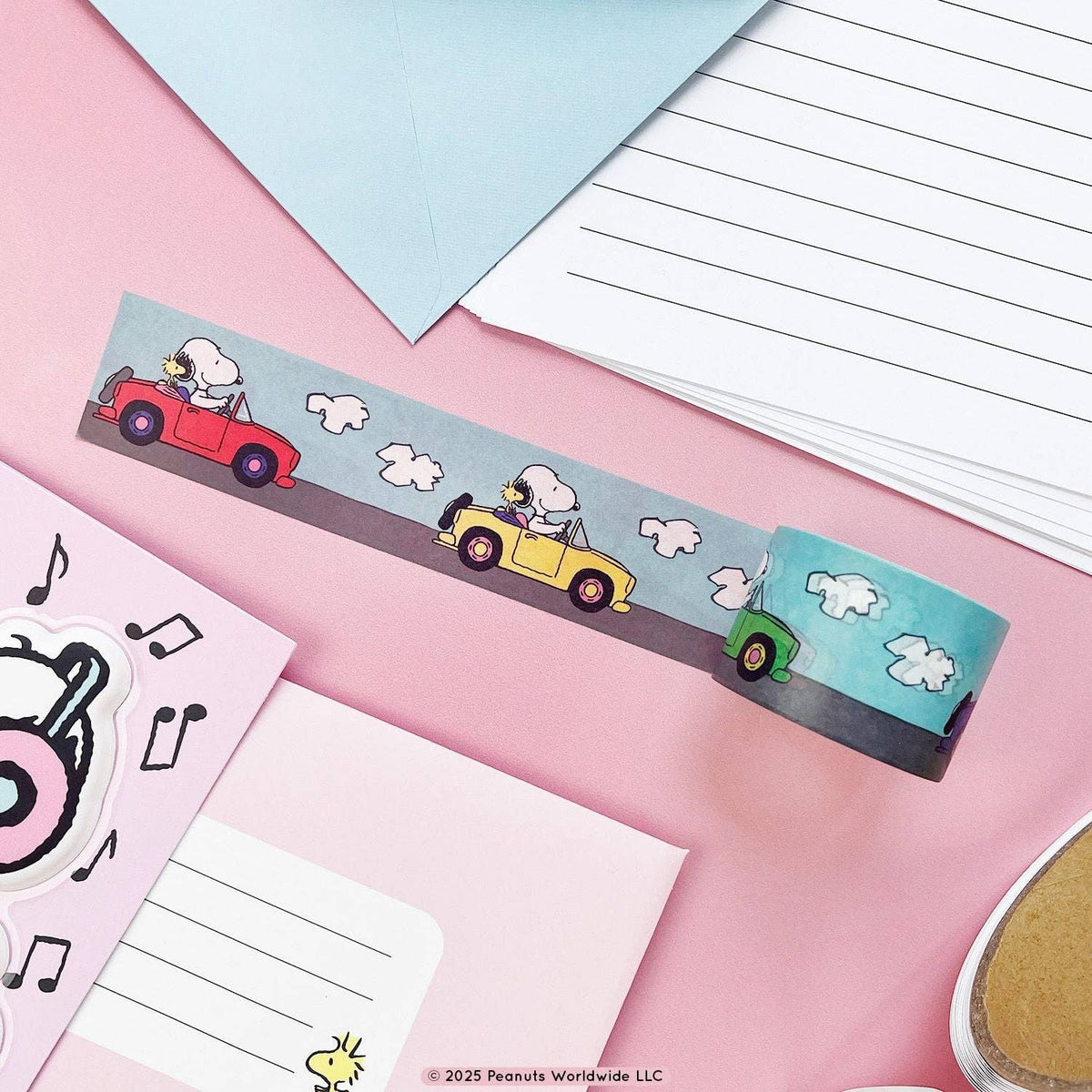 Decorative washi tape strip with Snoopy and Woodstock in cars, pastel background